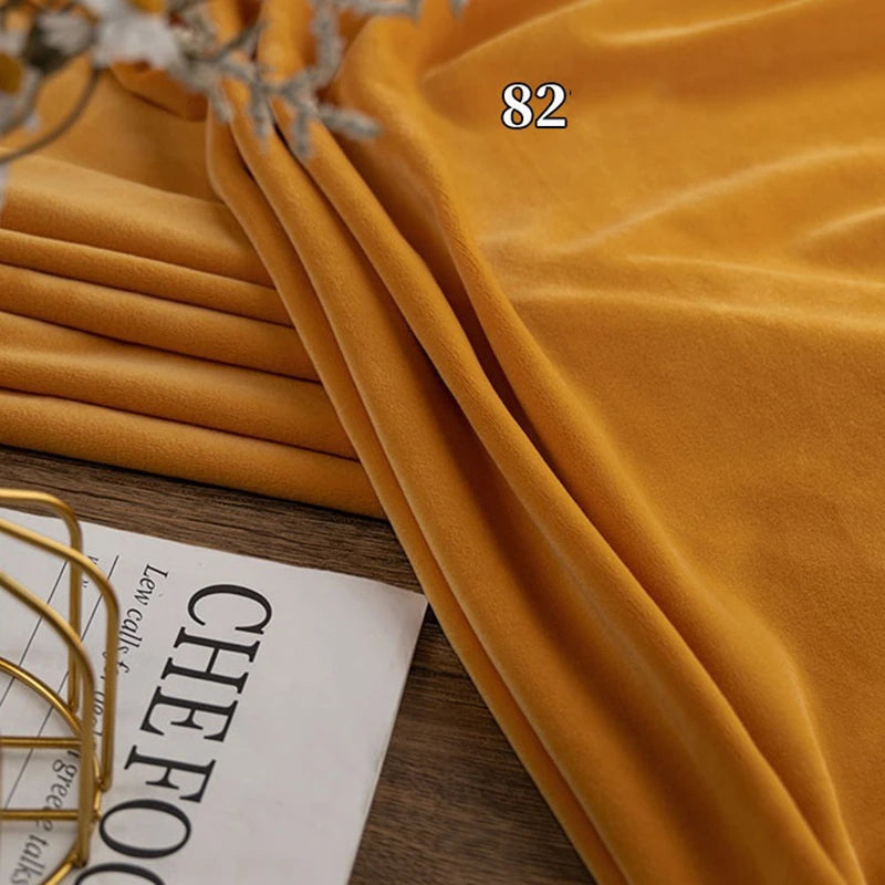 A folded piece of mustard yellow Longon Craft Stretch Minky Fabric By The Yard, labeled 82, rests beside a magazine partially showing the word "CHEFOOD.