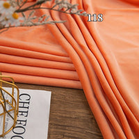 Longon Craft’s Stretch Minky Fabric by the Yard, shown in orange on a wooden surface with “118”, is perfect for cozy baby blankets, plushies, clothing, pillows, and other DIY projects. Four-way stretch cuddle material; ideal for crafts.