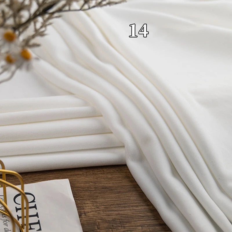 Longon Craft’s Stretch Minky Fabric By The Yard is neatly folded on a wooden surface with the number 14 shown above—dried flowers and an open book peek in, highlighting this cozy multicolor four-way stretch material for DIY clothing, plushies, or dolls.