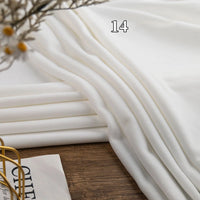 Longon Craft’s Stretch Minky Fabric By The Yard is neatly folded on a wooden surface with the number 14 shown above—dried flowers and an open book peek in, highlighting this cozy multicolor four-way stretch material for DIY clothing, plushies, or dolls.
