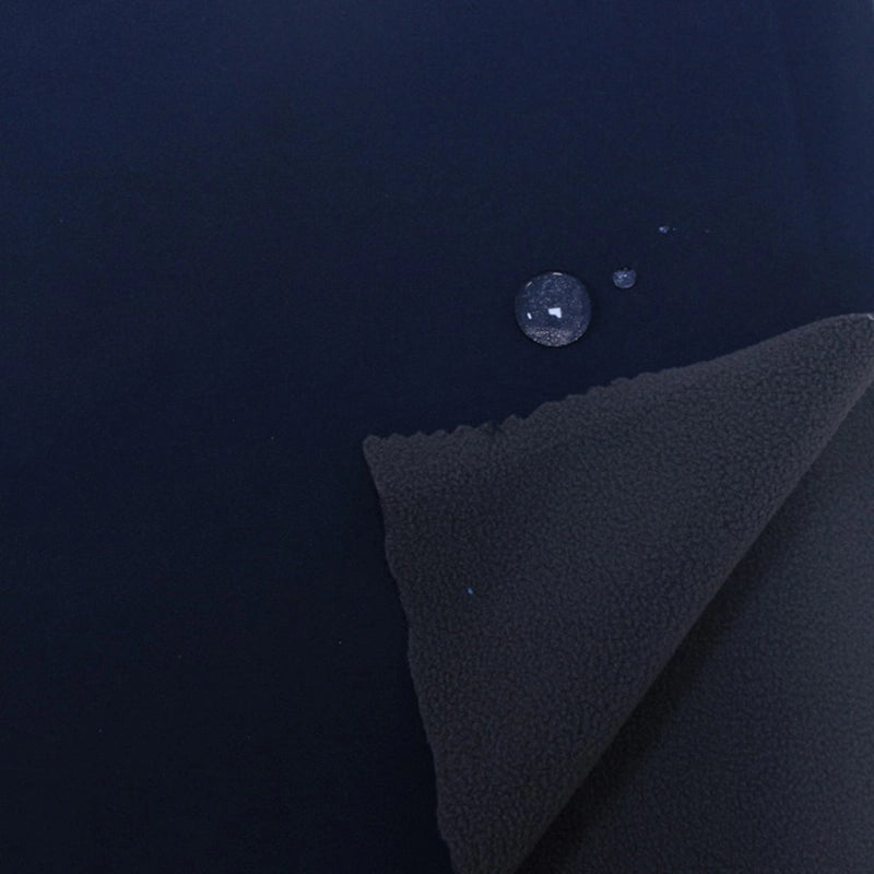 A close-up of Longon Craft Waterproof Polar Fleece Fabric By The Yard shows water beading on its surface, highlighting its water resistance. One corner is folded to reveal the soft underside of this 4-way stretch polyester fleece material.