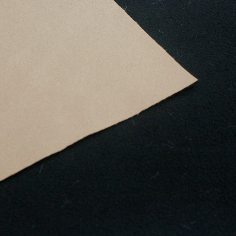 A close-up of Waterproof Polar Fleece Fabric By The Yard from Longon Craft, in brown, resting on a black surface; the 4-way stretch synthetic polyester resembles textures found in outdoor jackets.
