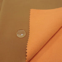 A close-up of Longon Craft Waterproof Polar Fleece Fabric By The Yard shows water beading on the smooth surface, demonstrating the 4-way stretch polyester material’s water-resistant properties.
